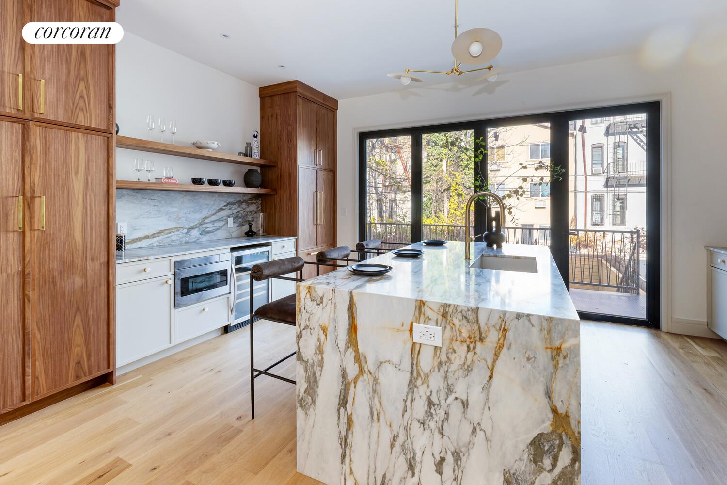 681 Decatur Street Brooklyn, NY 11233 - Photo 6 of 14 a view of a kitchen with kitchen island wooden floors and a view of living room
