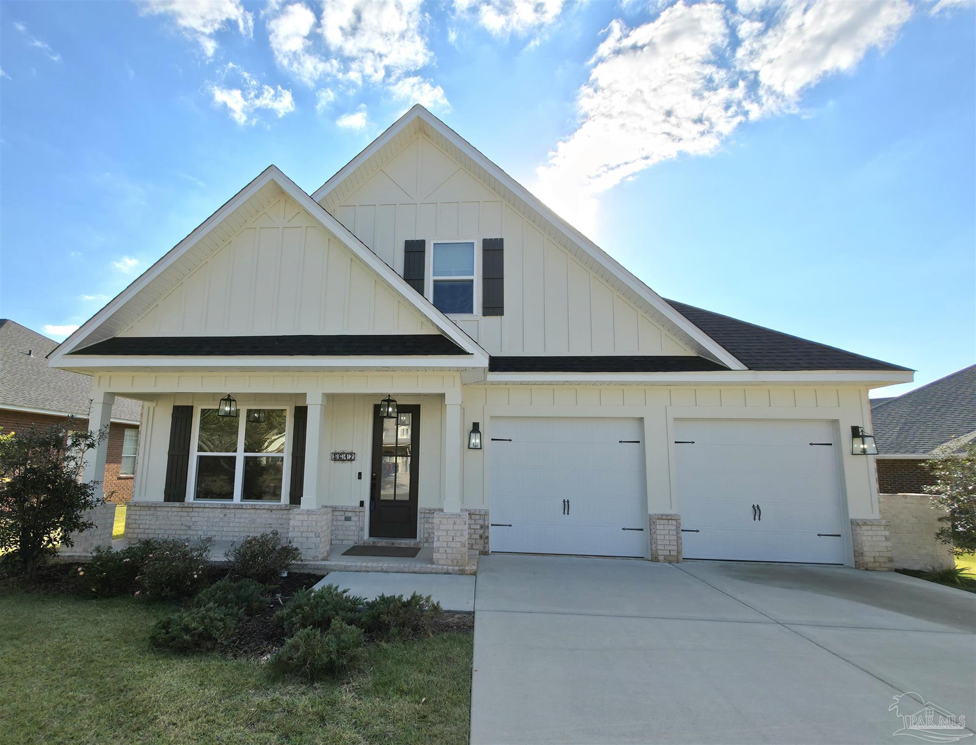 a view of a house with a yard and potted plants
