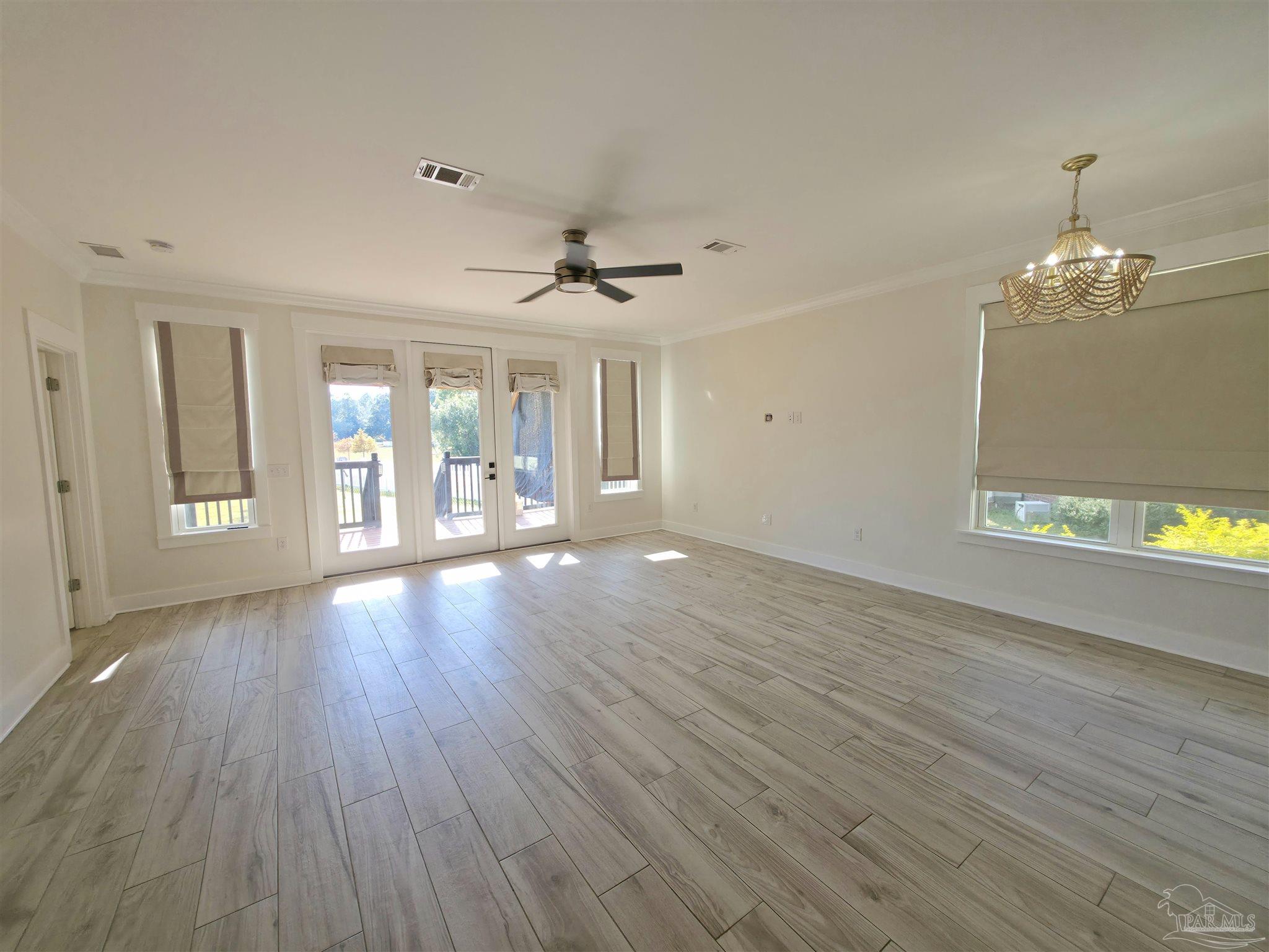5642 Dunbar Circle Milton, FL 32583 - Photo 14 of 33 a view of an empty room with wooden floor and a window