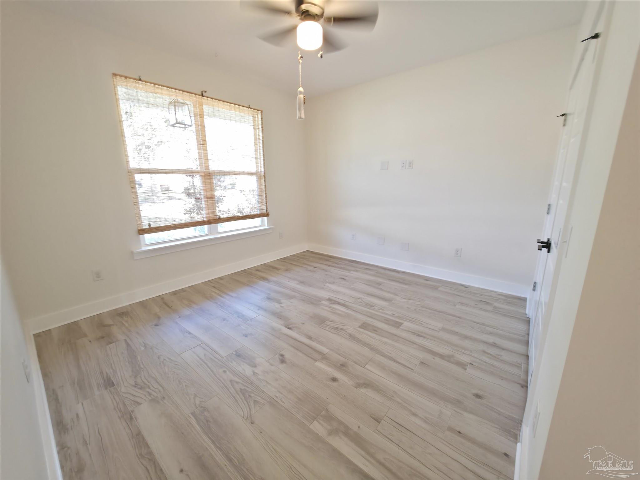 5642 Dunbar Circle Milton, FL 32583 - Photo 27 of 33 wooden floor in an empty room with a window