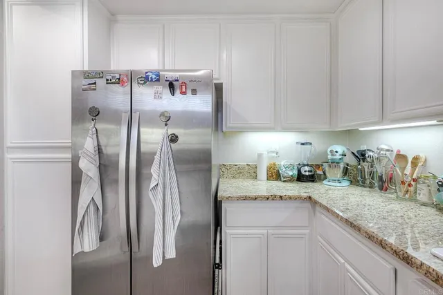 a kitchen with stainless steel appliances granite countertop a refrigerator and a sink