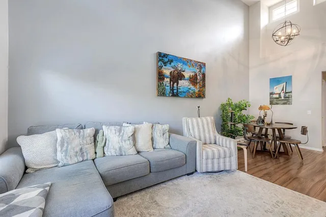 a living room with furniture and a dining table with wooden floor