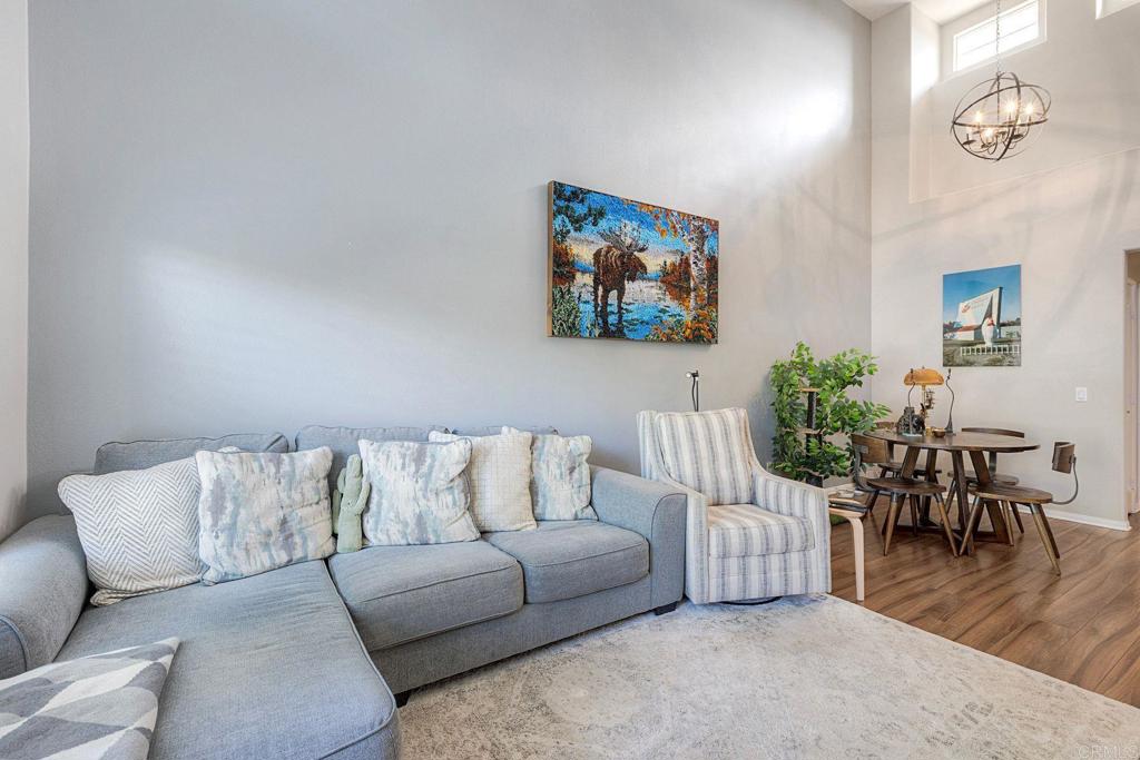 40238 Rosewell Court Temecula, CA 92591 - Photo 8 of 38 a living room with furniture and a dining table with wooden floor