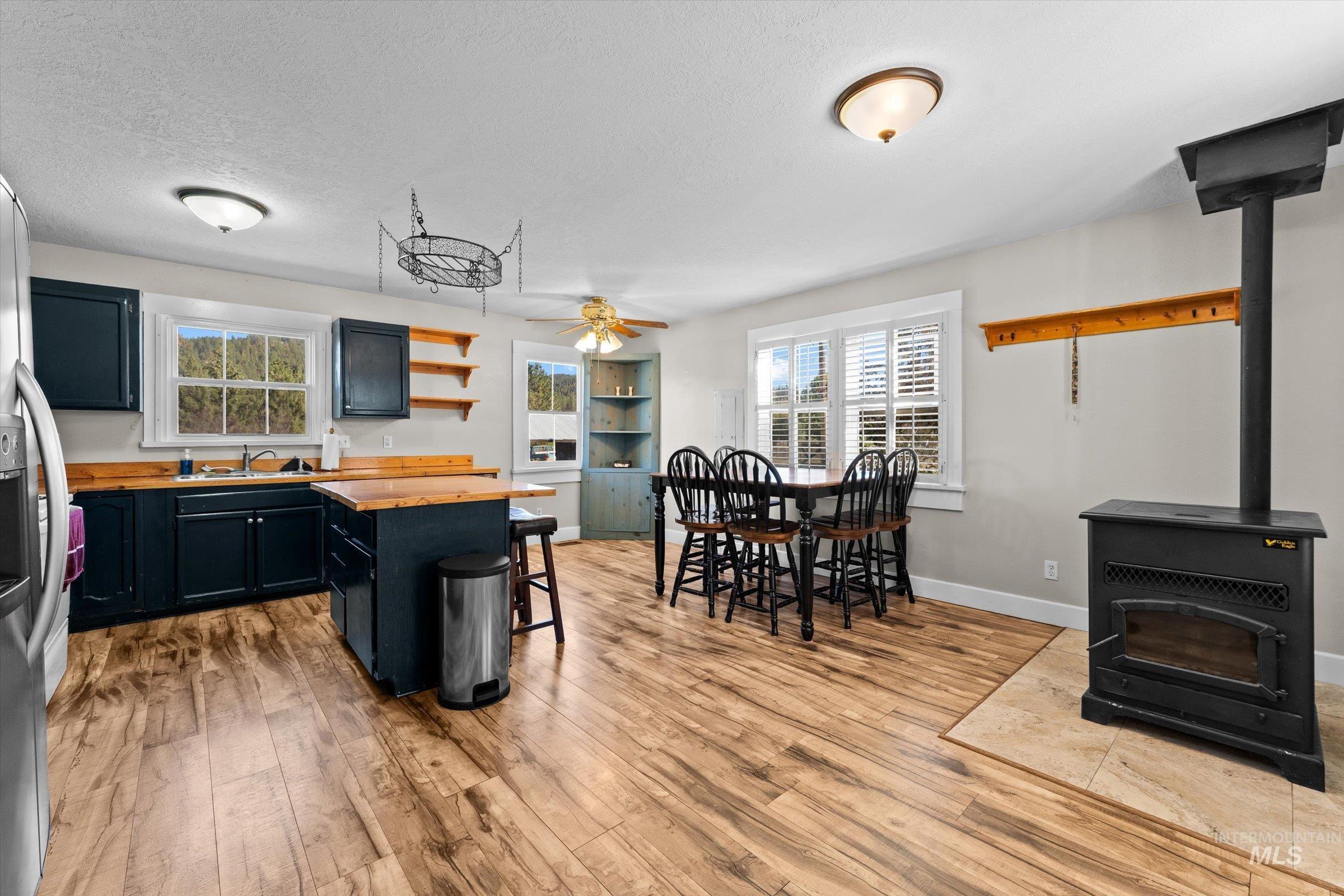 315 South Middlefork Road Garden Valley, ID 83622 - Photo 18 of 49 Kitchen with a wood stove, open shelves, dark cabinetry, a breakfast bar area, and butcher block countertops