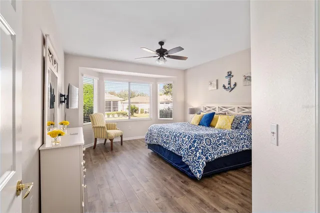 a bedroom with a bed and a flat tv screen on dresser