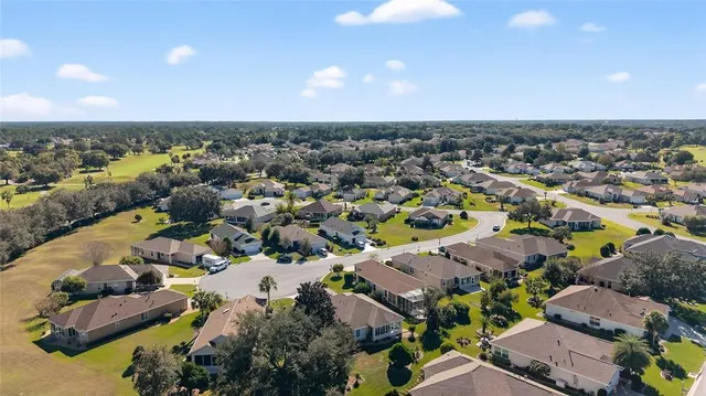 a front view of a house with garden and lots of trees