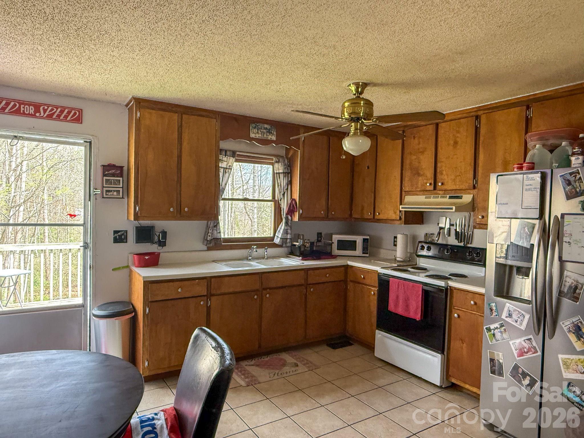 4562 Grassy Creek Road Denver, NC 28037 - Photo 21 of 24 a kitchen with stainless steel appliances granite countertop a sink a stove a refrigerator cabinets and dining table