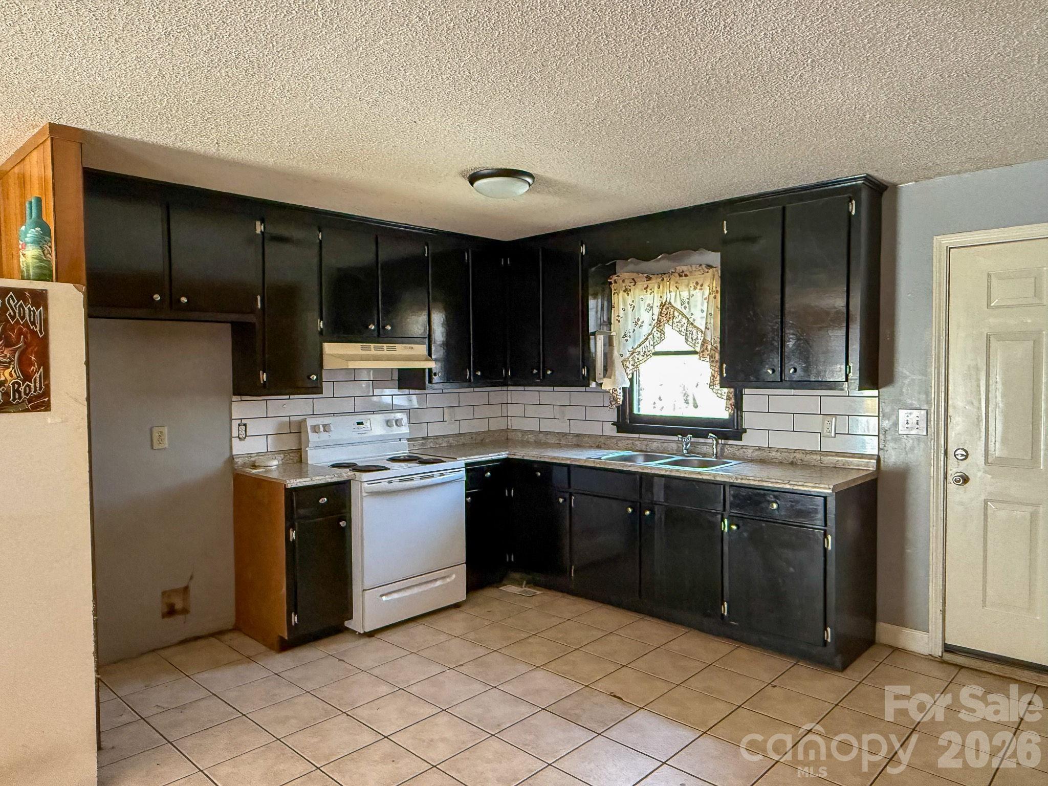 4562 Grassy Creek Road Denver, NC 28037 - Photo 10 of 24 a kitchen with stainless steel appliances granite countertop a sink and stove top oven