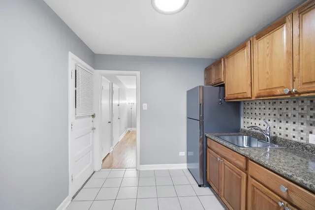a kitchen with granite countertop a sink a stove and cabinets