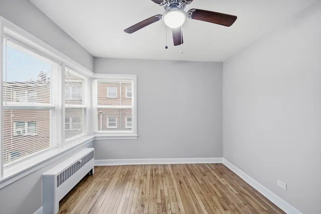 an empty room with a window and wooden floor