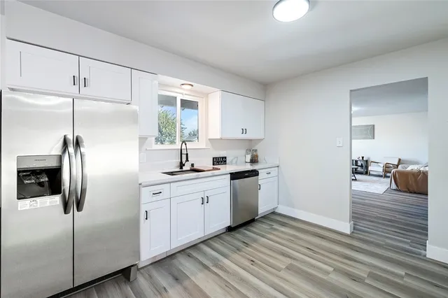 a kitchen with stainless steel appliances a refrigerator sink and cabinets