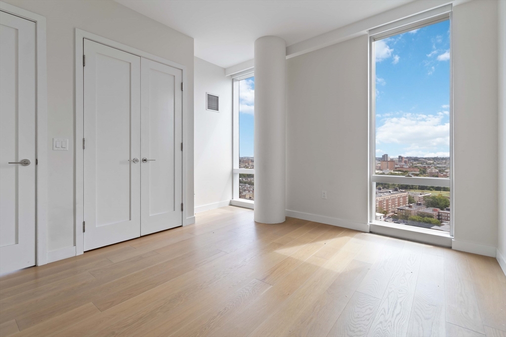 188 Brookline Avenue, Unit 20J Boston, MA 02215 - Photo 17 of 29 a view of an empty room with wooden floor and a window