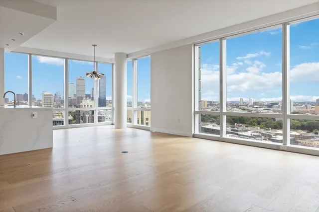 a view of an empty room with wooden floor and a floor to ceiling window