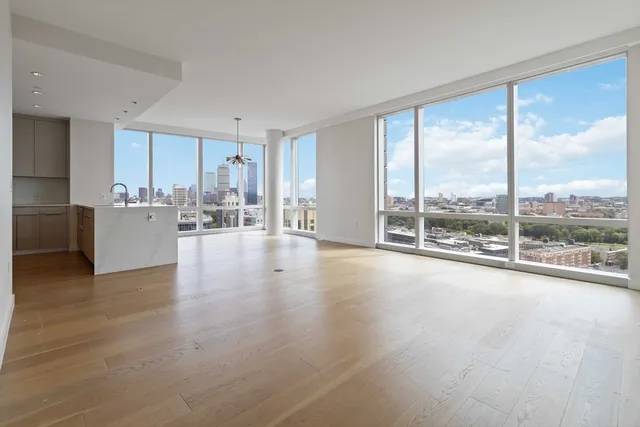 a view of a living room hardwood floor and a large window