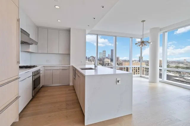 a kitchen with a sink a counter top space stainless steel appliances and cabinets