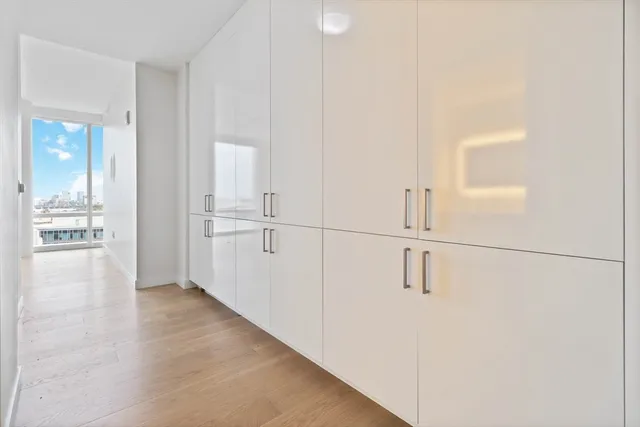 a view of a kitchen with white cabinets and wooden floor