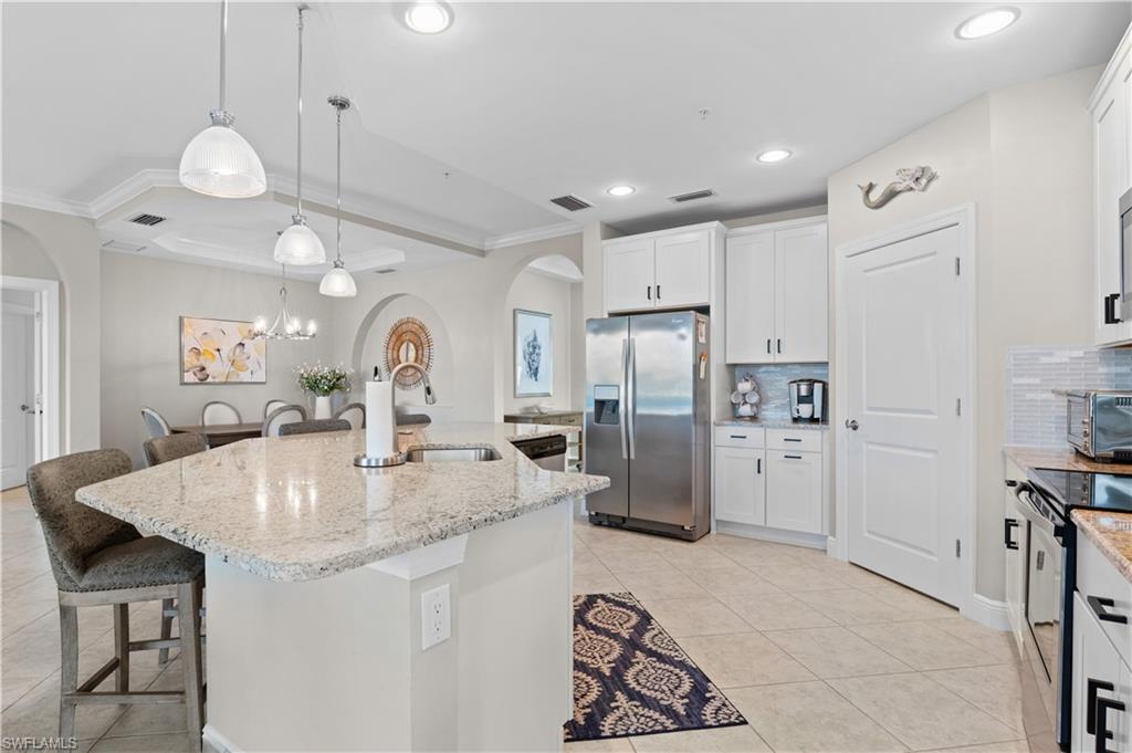 10470 Casella Way, Unit 101 Fort Myers, FL 33913 - Photo 8 of 20 a kitchen with refrigerator a sink and cabinets