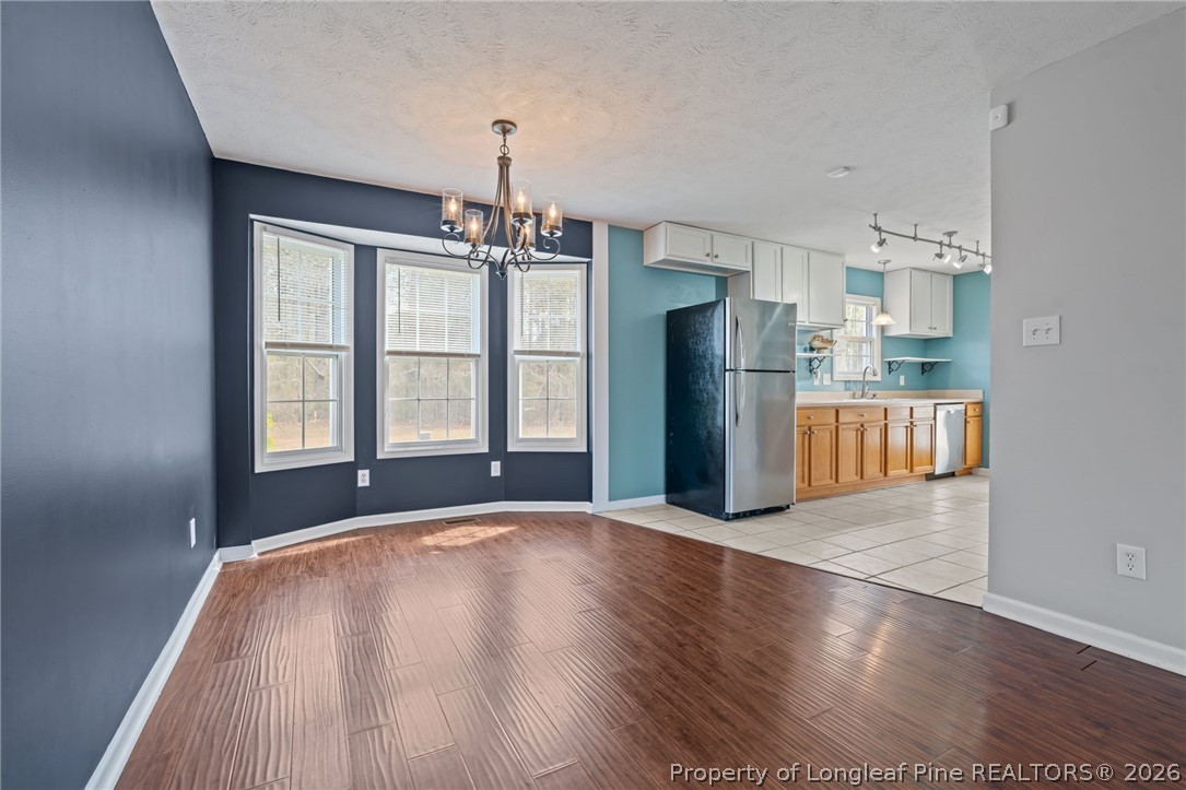 115 Shelby Street Spring Lake, NC 28390 - Photo 12 of 40 a view of a kitchen with refrigerator and wooden floor