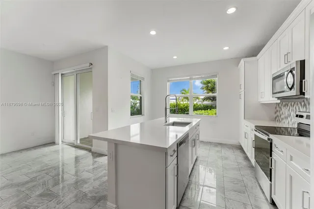a kitchen with stainless steel appliances granite countertop a sink and a stove