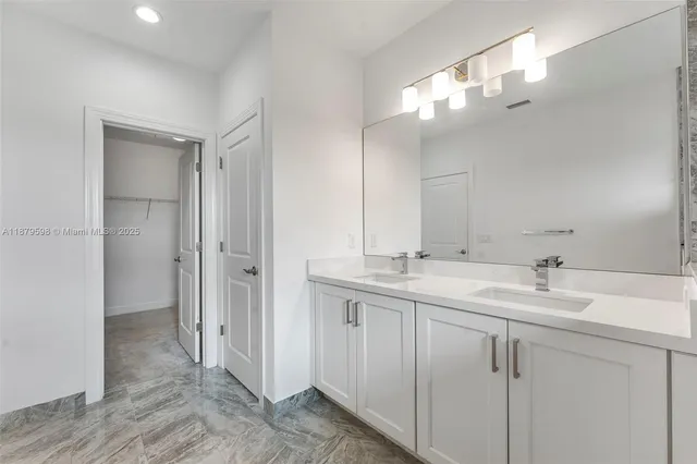 a bathroom with a double vanity sink mirror and