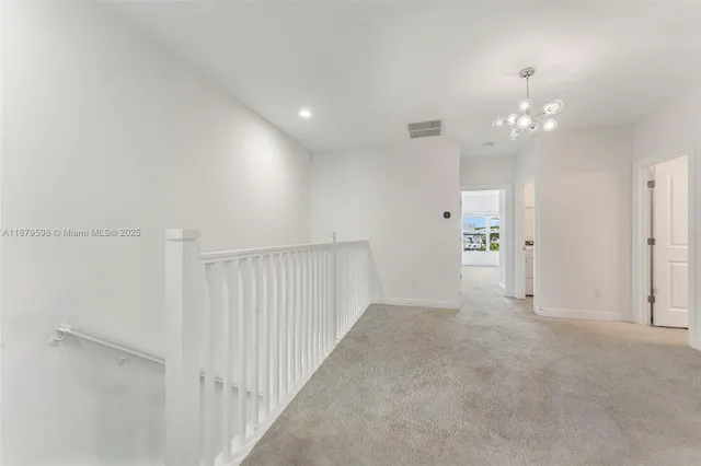 a view of a hallway with chandelier fan