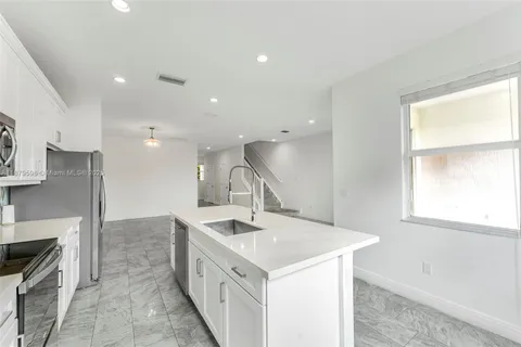 a kitchen with sink stove and cabinets