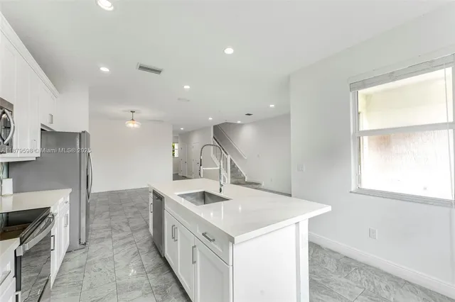 a kitchen with sink stove and cabinets