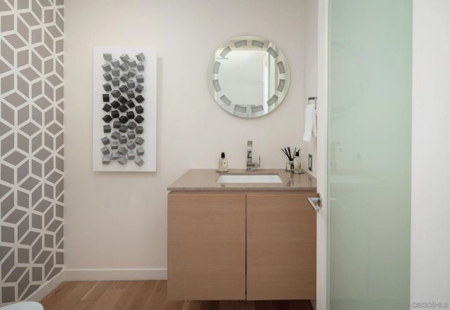 a bathroom with a granite countertop sink a mirror and shower