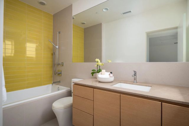 a bathroom with a granite countertop sink mirror toilet and bathtub