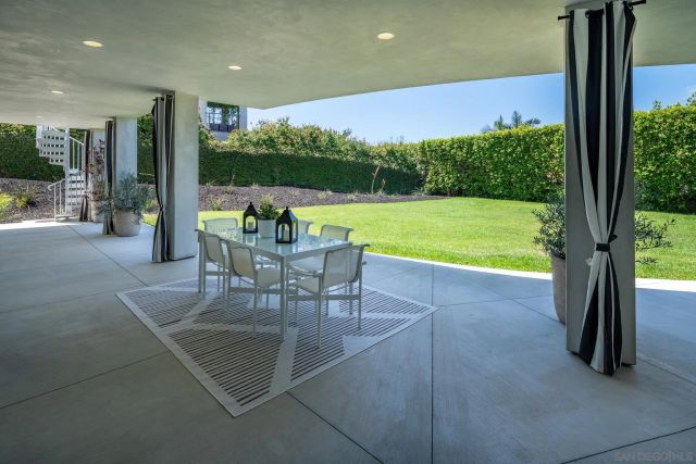 a view of a patio with a table chairs and a backyard