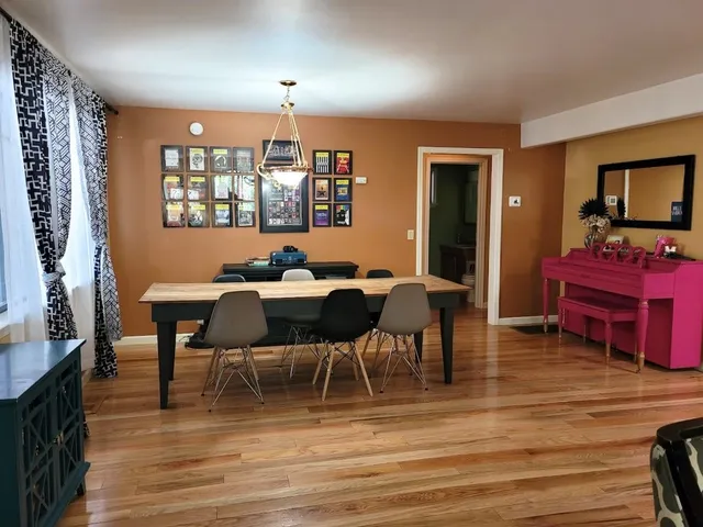 a view of a a dining room with furniture window and wooden floor