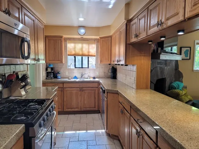 a kitchen with stainless steel appliances granite countertop a sink stove and cabinets