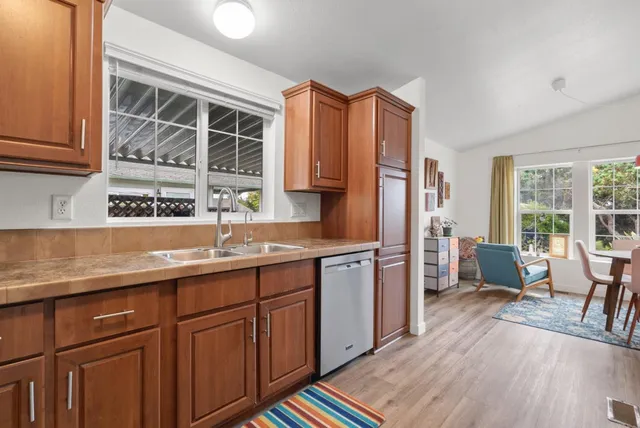 a kitchen with stainless steel appliances a sink cabinets and wooden floor