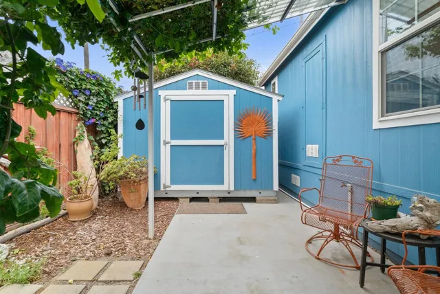 a backyard of a house with bicycles parked and wooden fence