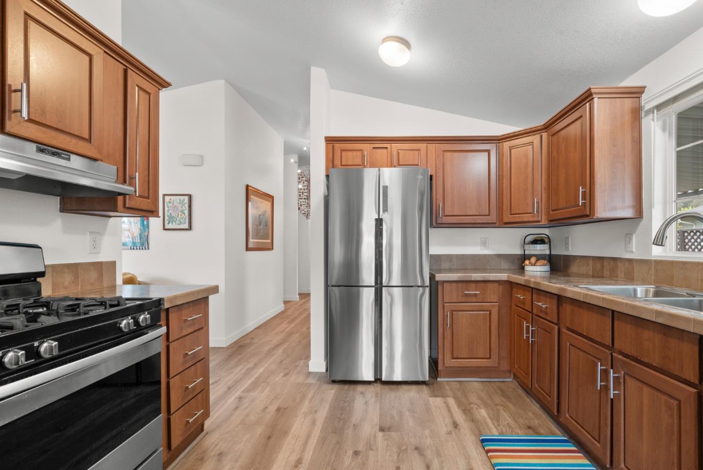2395 Delaware Avenue, Unit 88 Santa Cruz, CA 95060 - Photo 10 of 55 a kitchen with a refrigerator stove and wooden cabinets