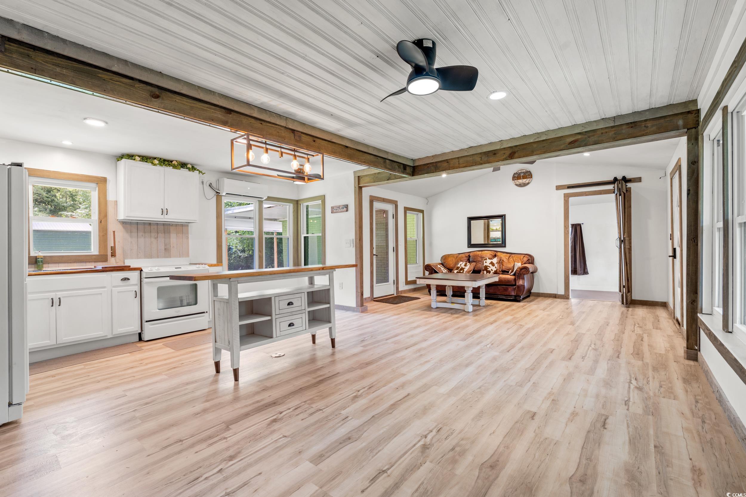 3974 North Fraser Street Georgetown, SC 29440 - Photo 36 of 36 Kitchen with beamed ceiling, white appliances, white cabinetry, open floor plan, and light wood-type flooring