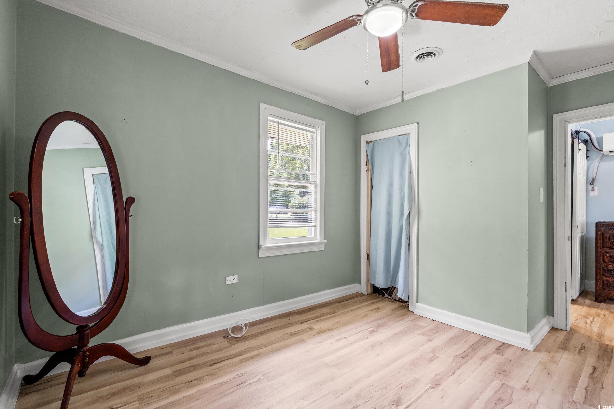 3974 North Fraser Street Georgetown, SC 29440 - Photo 14 of 36 Unfurnished bedroom featuring light wood-style flooring, crown molding, and ceiling fan