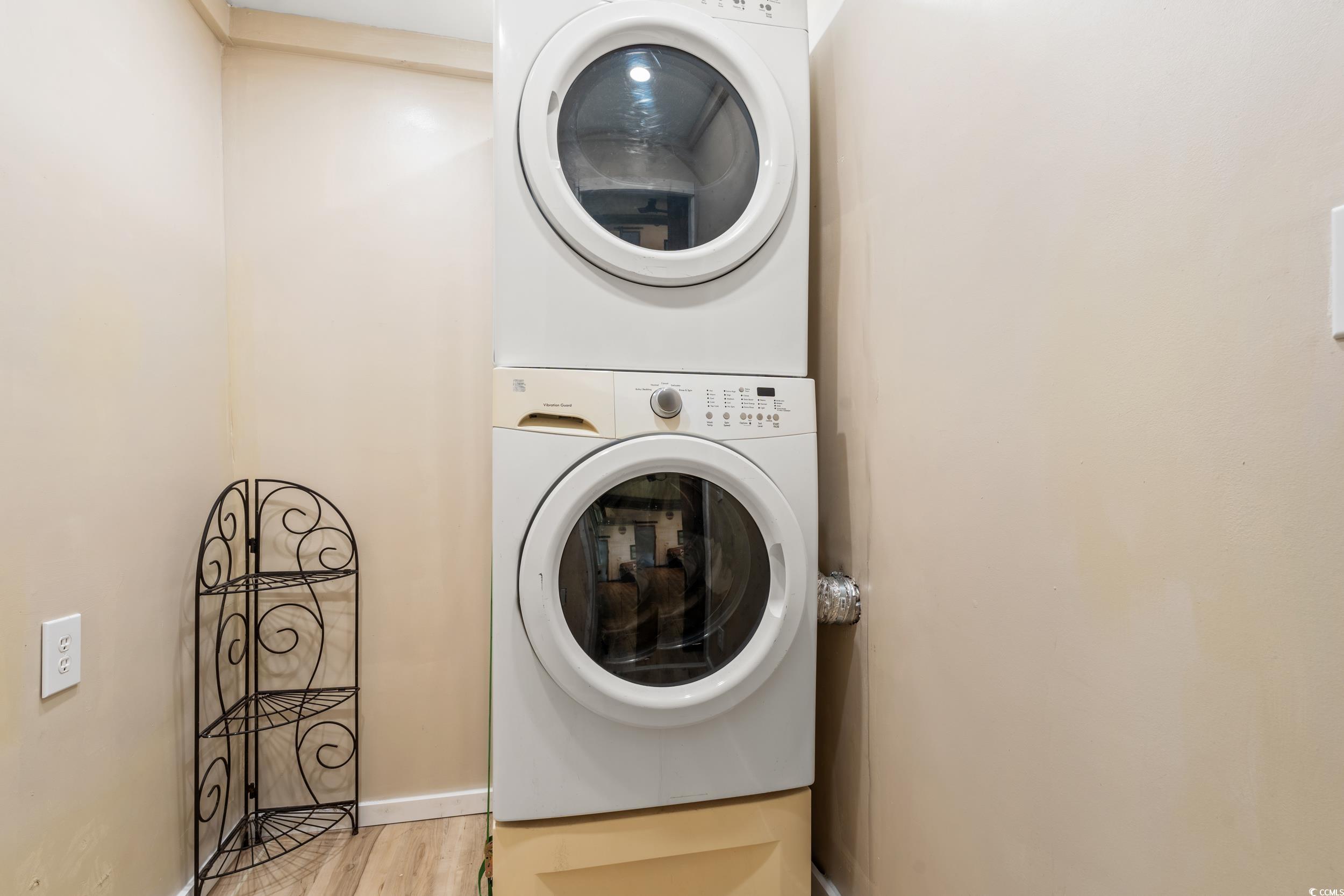 3974 North Fraser Street Georgetown, SC 29440 - Photo 19 of 36 Laundry room with stacked washer and clothes dryer and wood finished floors
