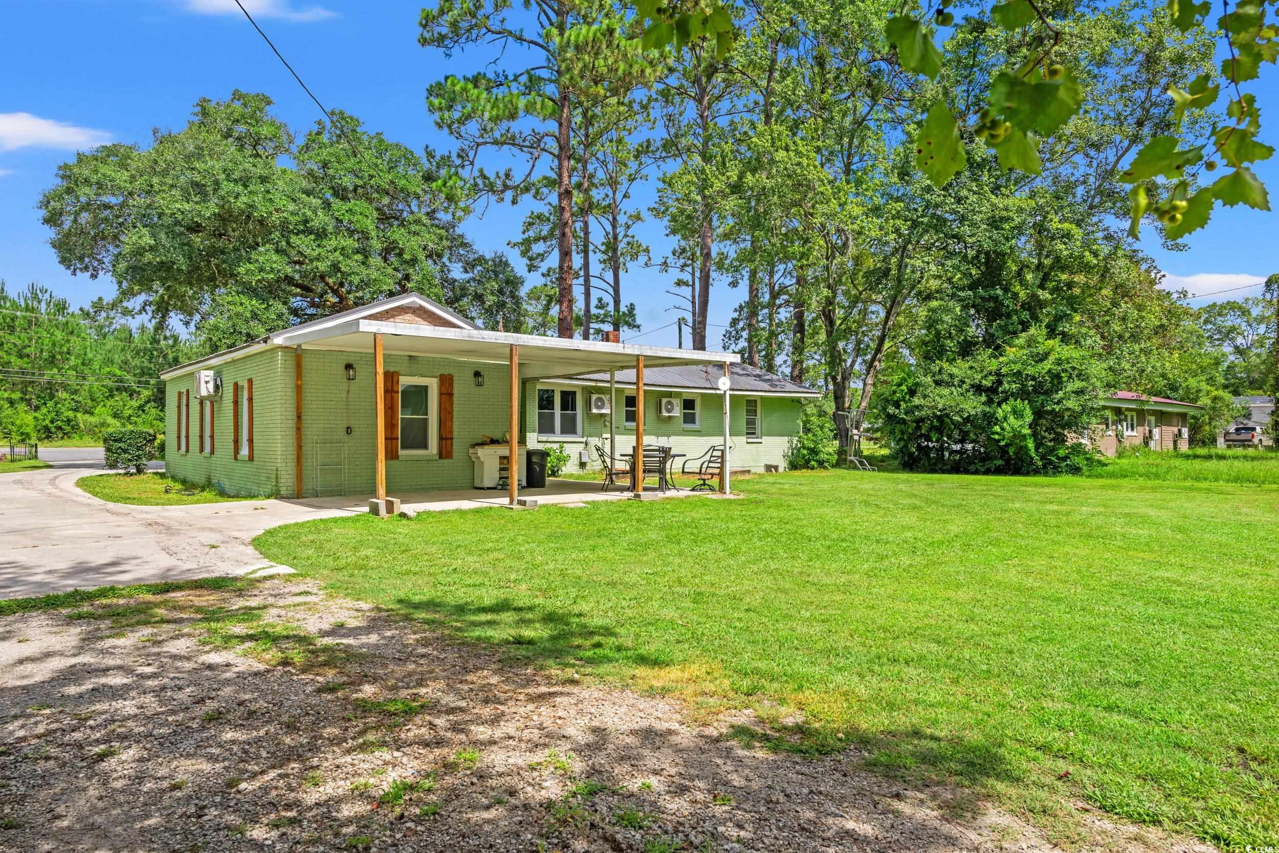 3974 North Fraser Street Georgetown, SC 29440 - Photo 23 of 36 View of front facade with driveway, a front yard, brick siding, and a carport