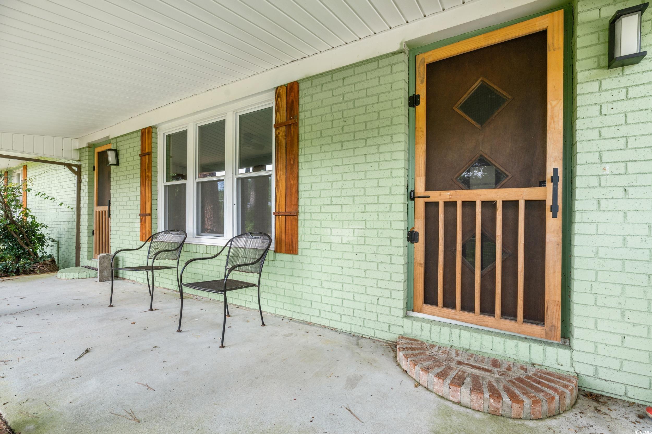 3974 North Fraser Street Georgetown, SC 29440 - Photo 25 of 36 View of exterior entry with covered porch and brick siding