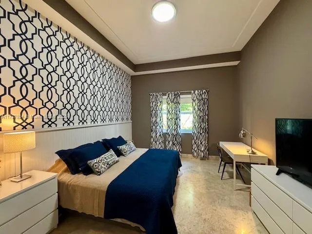 a bedroom with a bed and a flat screen tv