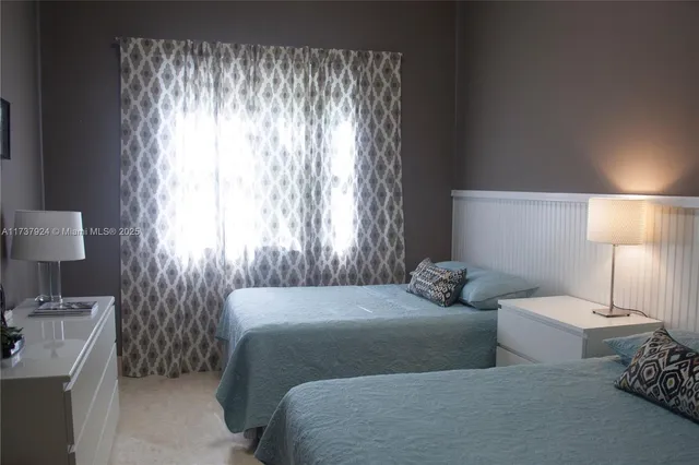 a bedroom with two beds and a lamp