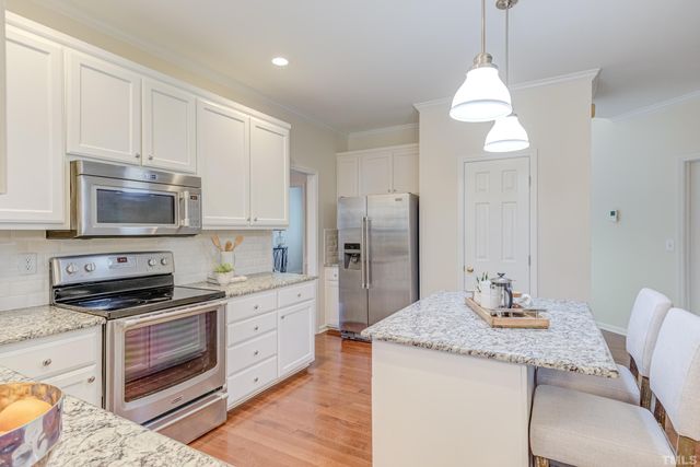 a kitchen with stainless steel appliances granite countertop a stove a sink and a refrigerator