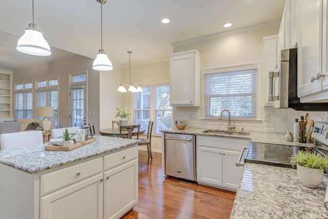 a large kitchen with granite countertop a sink a stove counter space and dining table