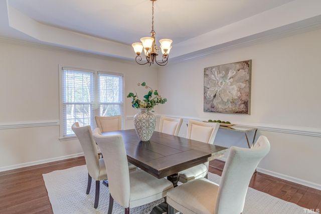 a view of a dining room with furniture a chandelier and wooden floor