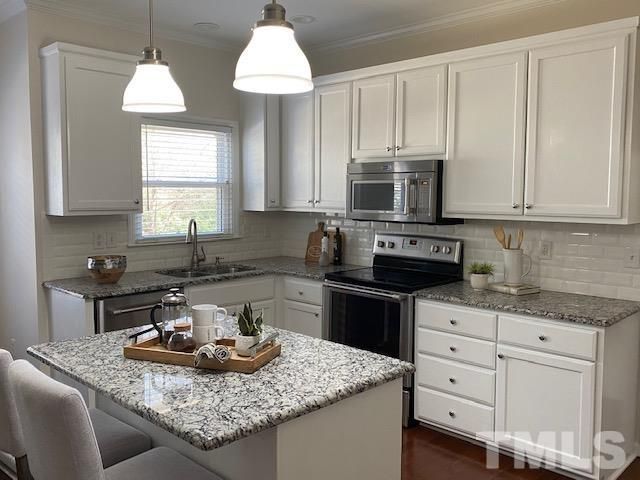 a kitchen with granite countertop a sink a stove and a microwave