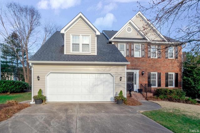 a view of a house with a yard and large tree