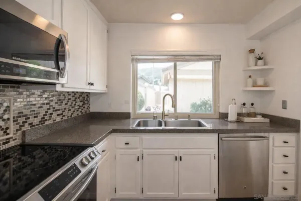 a kitchen with a refrigerator and a stove top oven