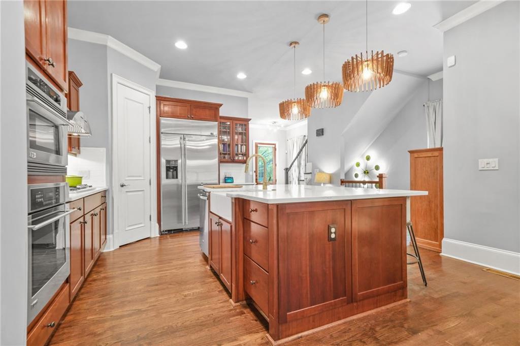 385 15th Street Northwest, Unit 6 Atlanta, GA 30363 - Photo 13 of 49 a kitchen with stainless steel appliances granite countertop a refrigerator a sink dishwasher a oven and a dining table with wooden floor