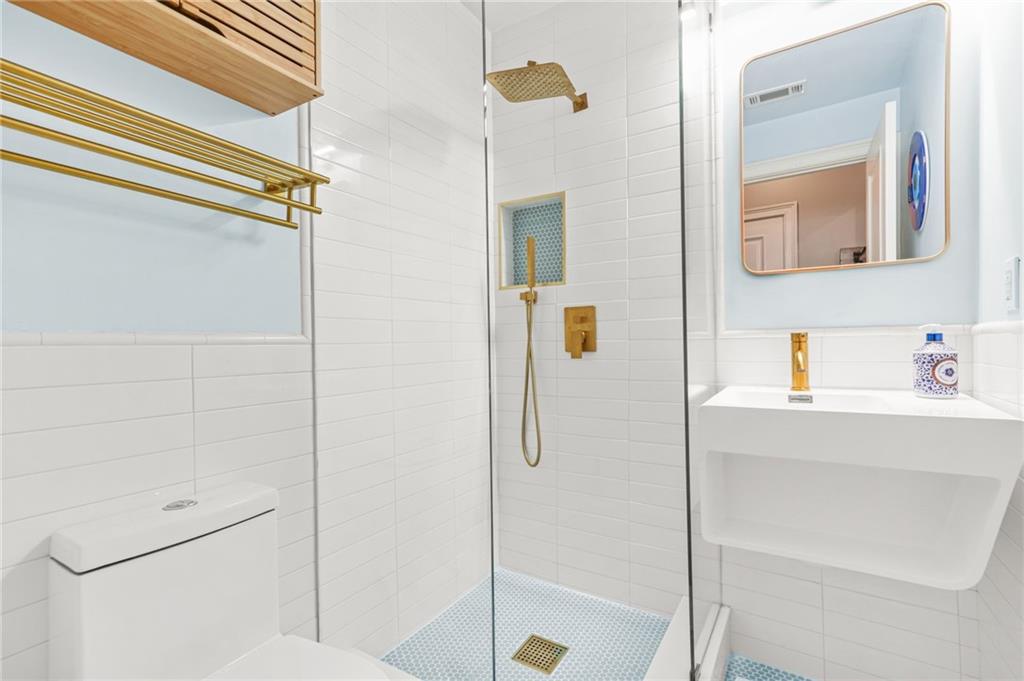 385 15th Street Northwest, Unit 6 Atlanta, GA 30363 - Photo 37 of 49 a bathroom with a shower a mirror and a sink